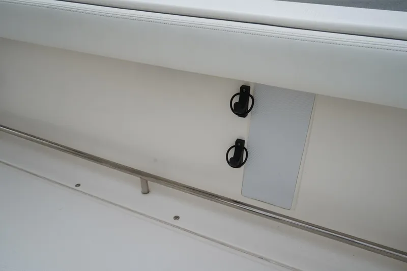 Slide: The Image of 2023 Robalo R222 Explorer interior detail with rod holders and white upholstery. - 13