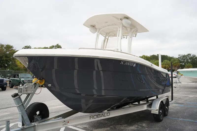 Slide: The Image of 2023 Robalo R222 Explorer boat on trailer, parked outdoors. - 2