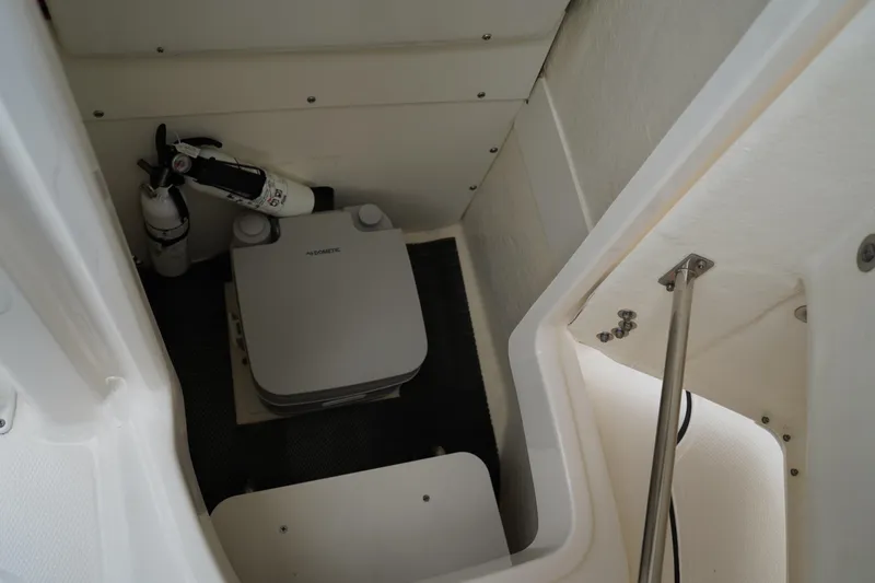 Slide: The Image of 2023 Robalo R222 Explorer boat interior with portable toilet and fire extinguisher. - 23