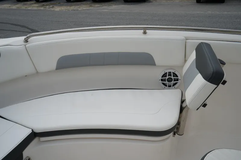 Slide: The Image of 2023 Robalo R222 Explorer boat interior with white cushioned seating and speaker. - 26