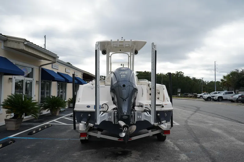 Slide: The Image of 2023 Robalo R222 Explorer boat with Yamaha engine, parked outside a building under cloudy skies. - 7