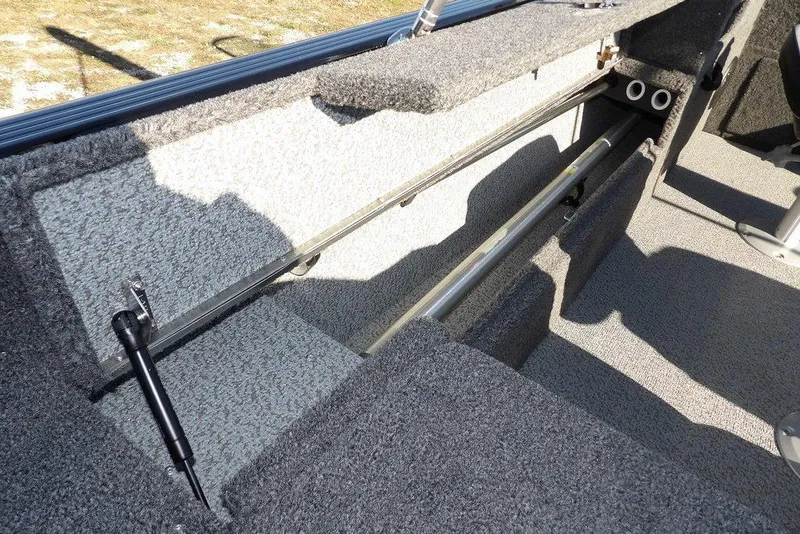 Slide: The Image of 2026 Lund 1875 Impact XS Sport boat interior storage compartment with carpeted finish. - 12