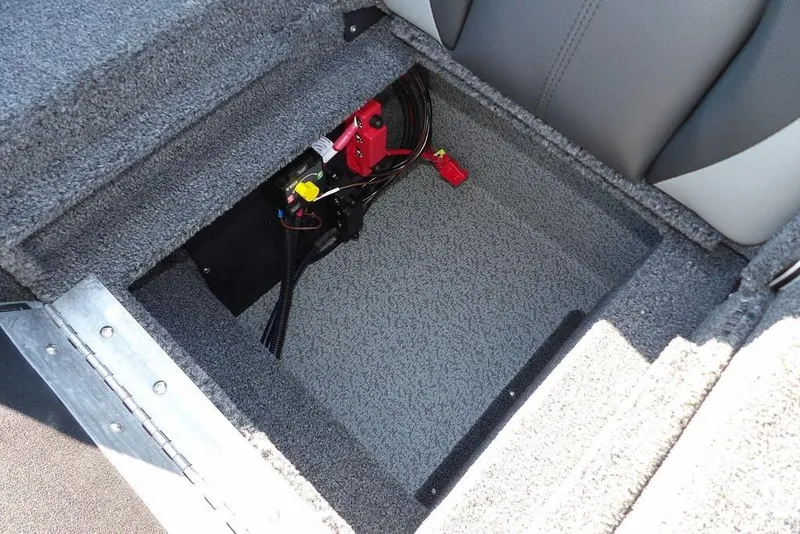 Slide: The Image of 2026 Lund 1875 Impact XS Sport boat storage compartment with wiring and carpeted interior. - 14
