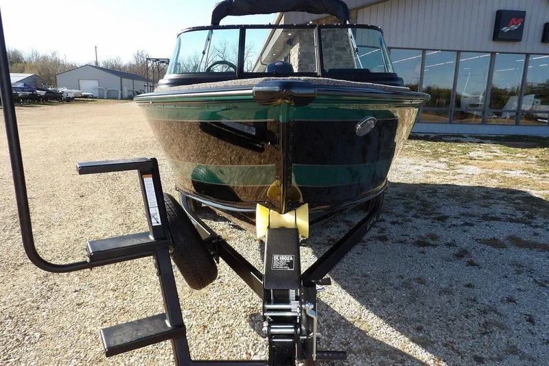 Slide: The Image of 2026 Lund 1875 Impact XS Sport boat on trailer, parked outdoors. - 2