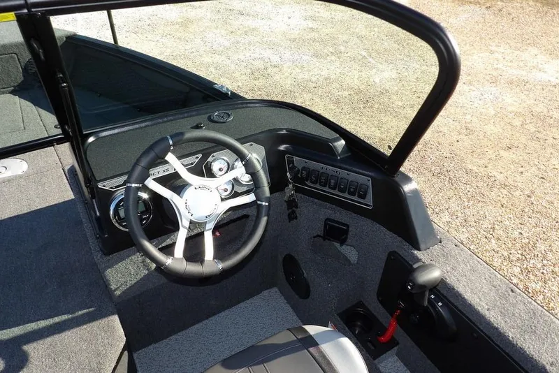 Slide: The Image of 2026 Lund 1875 Impact XS Sport boat cockpit with steering wheel and control panel. - 22