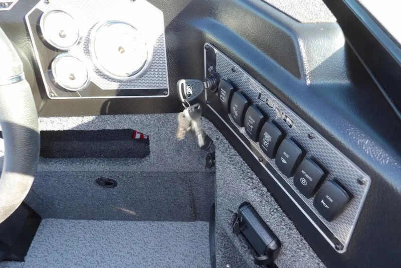 Slide: The Image of 2026 Lund 1875 Impact XS Sport dashboard with control panel and ignition keys. - 26