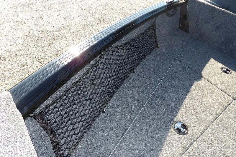 Slide: The Image of 2026 Lund 1875 Impact XS Sport boat interior with storage net and carpeted floor. - 42