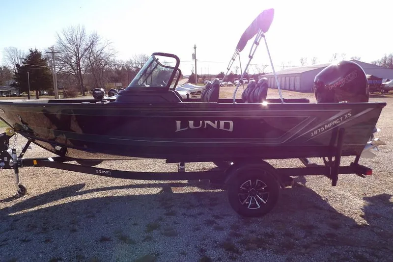 Slide: The Image of 2026 Lund 1875 Impact XS Sport boat on trailer, parked outdoors. - 5