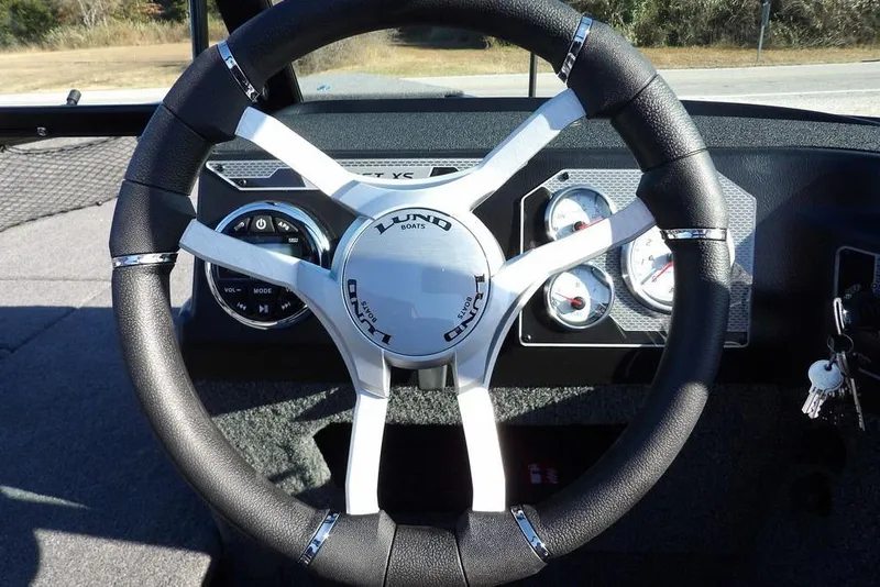 Slide: The Image of Steering wheel of 2026 Lund 1875 Impact XS Sport boat with dashboard controls. - 50