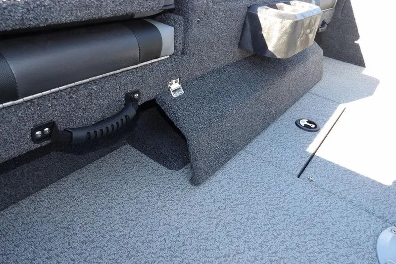 Slide: The Image of Interior of 2026 Lund 1875 Impact XS Sport boat, featuring carpeted flooring and seating. - 51