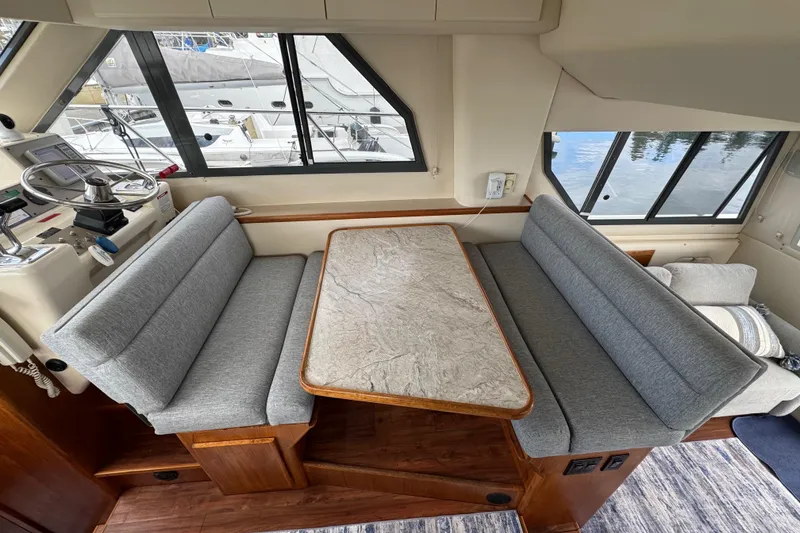 Slide: The Image of Interior of 1996 Carver 370 Voyager with gray seating and wooden table. - 12