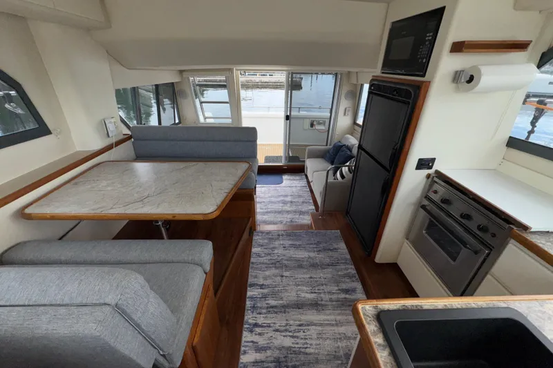 Slide: The Image of Interior of 1996 Carver 370 Voyager yacht with dining area, kitchen, and seating. - 15