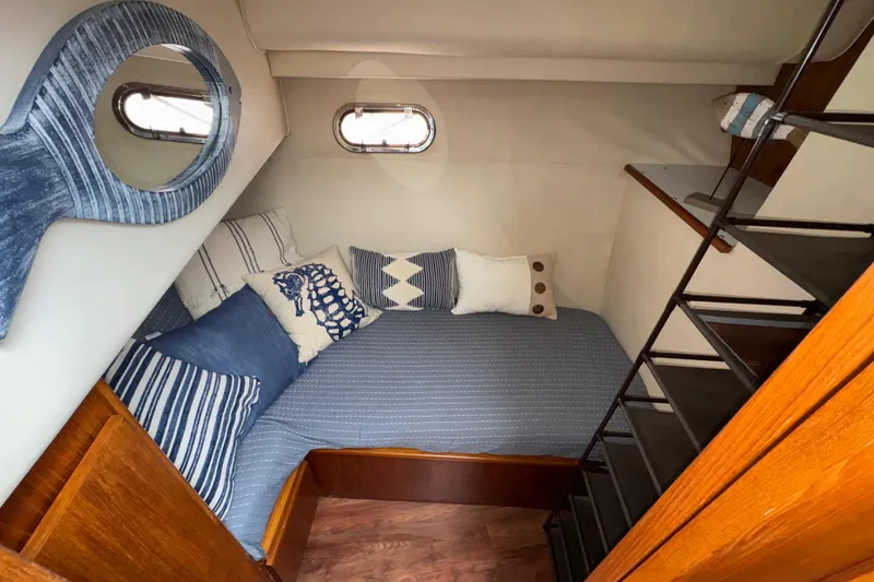 Slide: The Image of Cozy cabin interior of 1996 Carver 370 Voyager with nautical-themed bedding and wooden accents. - 20