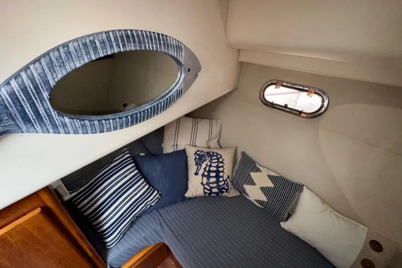Slide: The Image of Cozy cabin interior of 1996 Carver 370 Voyager with nautical-themed pillows and porthole. - 21