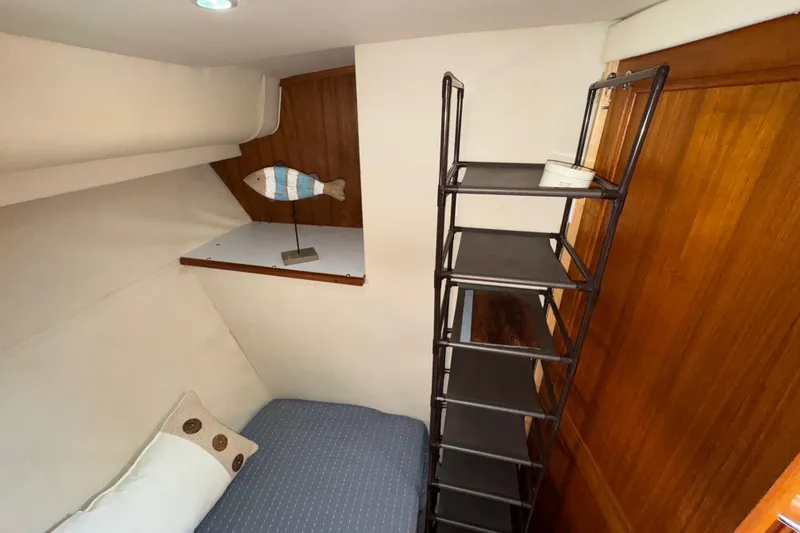 Slide: The Image of 1996 Carver 370 Voyager cabin interior with bed, decorative fish, and shelving. - 22