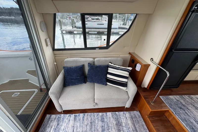 Slide: The Image of Interior of 1996 Carver 370 Voyager with sofa, cushions, and marina view. - 3