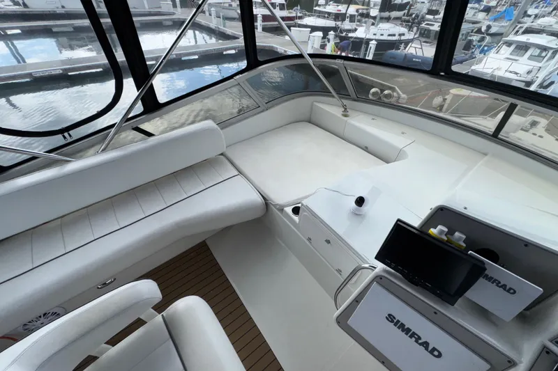 Slide: The Image of 1996 Carver 370 Voyager yacht interior with white seating and Simrad navigation system. - 33