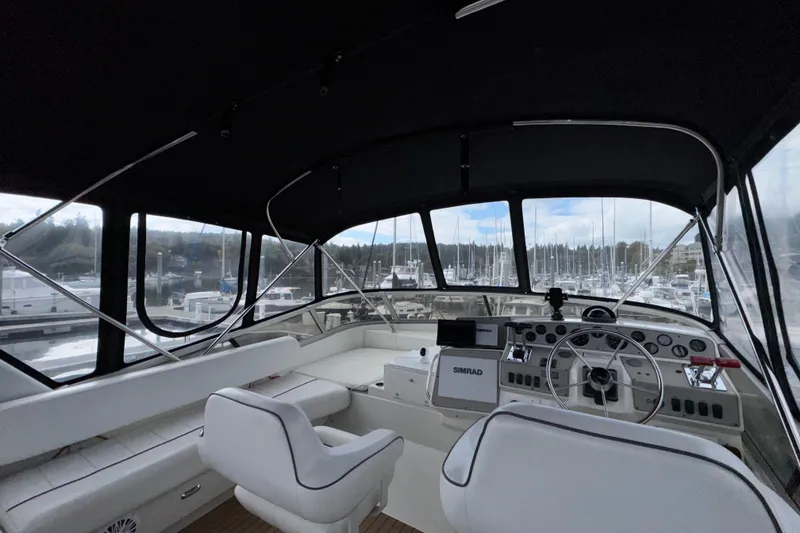 Slide: The Image of Interior view of 1996 Carver 370 Voyager yacht helm with marina background. - 34