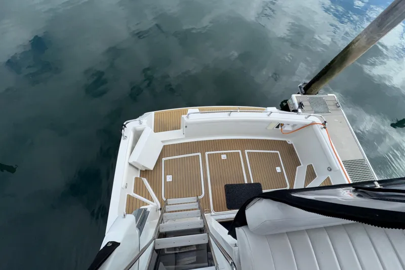 Slide: The Image of 1996 Carver 370 Voyager boat deck with wooden flooring, docked on calm water. - 38