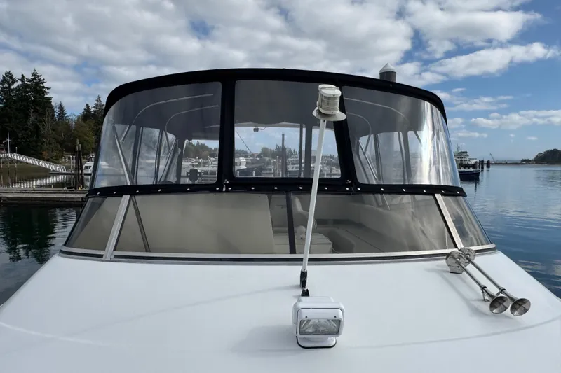 Slide: The Image of 1996 Carver 370 Voyager yacht docked, featuring a clear windshield and calm waters. - 39