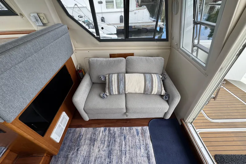 Slide: The Image of Cozy interior of 1996 Carver 370 Voyager with a gray sofa and striped pillow. - 4