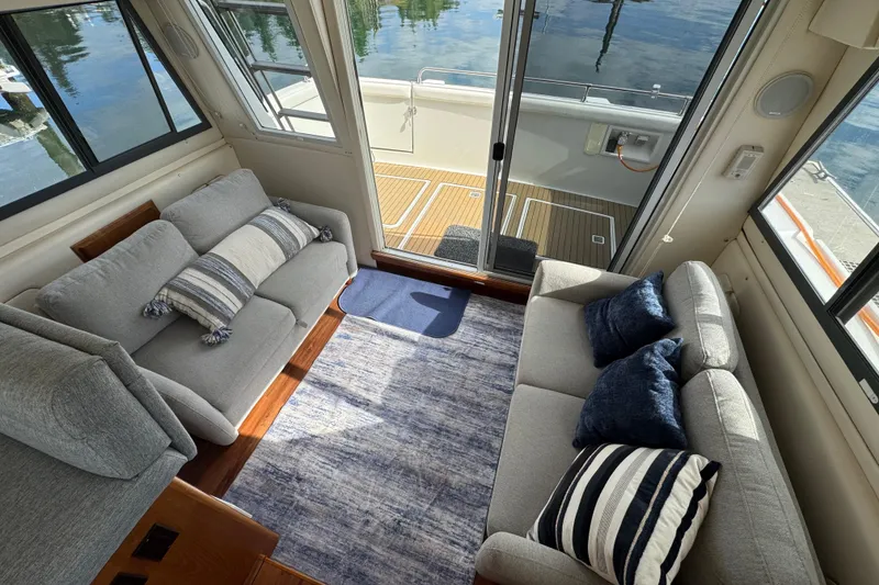 Slide: The Image of Interior of 1996 Carver 370 Voyager yacht with cozy seating and decorative pillows. - 6
