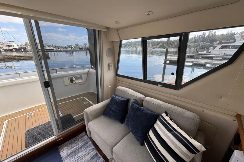 Slide: The Image of Interior of 1996 Carver 370 Voyager yacht with cozy seating and marina view. - 8