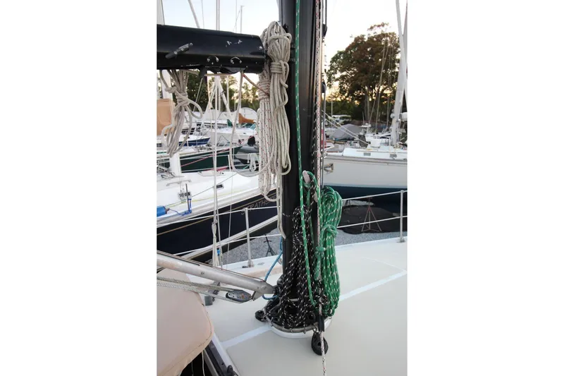 Slide: The Image of 1981 Ericson 36 sailboat deck with ropes and mast in marina setting. - 10