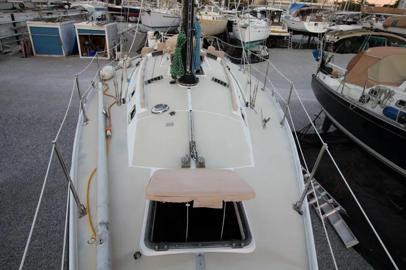Slide: The Image of 1981 Ericson 36 sailboat on dry dock, surrounded by other boats. - 11