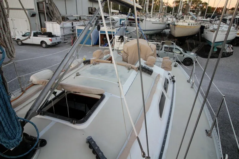 Slide: The Image of 1981 Ericson 36 sailboat on land, surrounded by other boats and vehicles. - 12