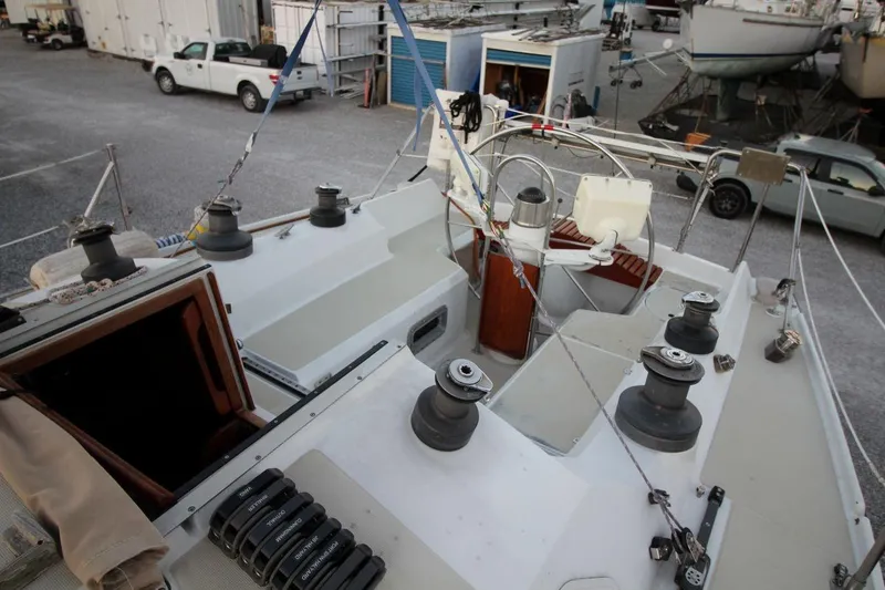 Slide: The Image of 1981 Ericson 36 sailboat deck with winches and rigging in a boatyard. - 13