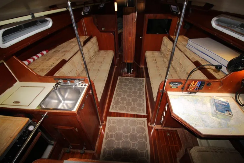 Slide: The Image of Interior of 1981 Ericson 36 sailboat with cozy seating, kitchenette, and navigation area. - 20