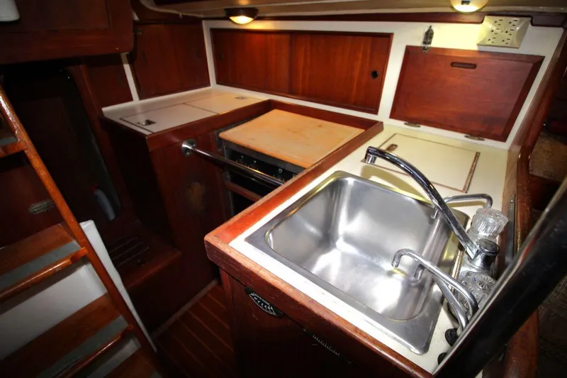 Slide: The Image of 1981 Ericson 36 yacht kitchen with wooden cabinets and stainless steel sink. - 21