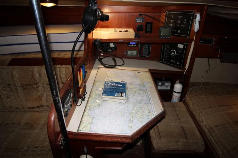 Slide: The Image of Navigation station inside 1981 Ericson 36 sailboat with map, notebook, and instruments. - 22
