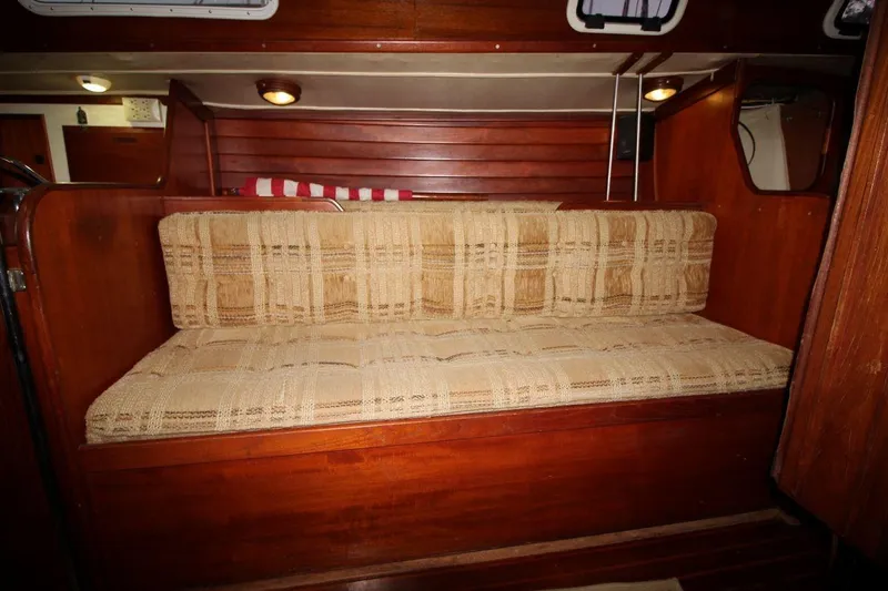 Slide: The Image of Interior of 1981 Ericson 36 sailboat with plaid cushioned seating and wooden paneling. - 24