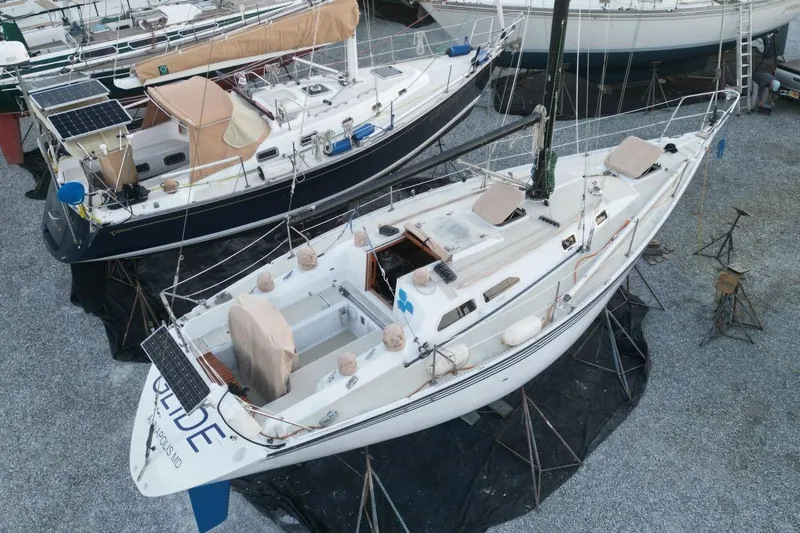 Slide: The Image of 1981 Ericson 36 sailboat on stands, surrounded by other boats in a gravel yard. - 8