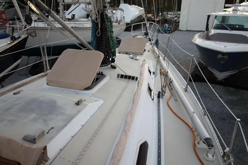 Slide: The Image of 1981 Ericson 36 sailboat deck with rigging and hatches, docked alongside other boats. - 9