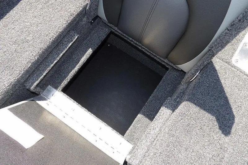 Slide: The Image of Storage compartment in 2026 Lund 1875 Pro-V Bass XS boat, featuring carpeted interior. - 16