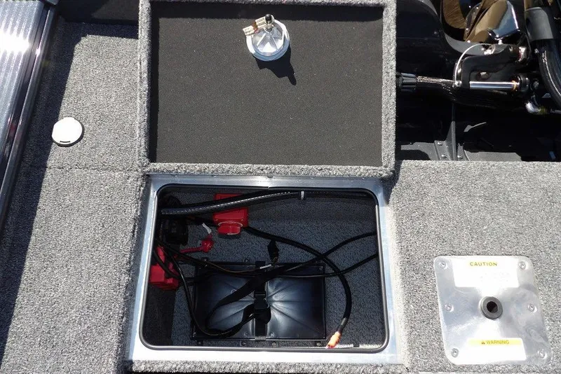Slide: The Image of 2026 Lund 1875 Pro-V Bass XS boat battery compartment with wiring and caution label. - 18