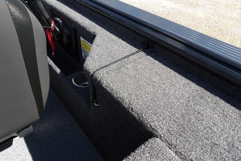 Slide: The Image of Interior of 2026 Lund 1875 Pro-V Bass XS boat, featuring carpeted storage and cup holder. - 24