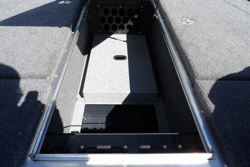 Slide: The Image of 2026 Lund 1875 Pro-V Bass XS boat storage compartment with carpeted interior. - 41