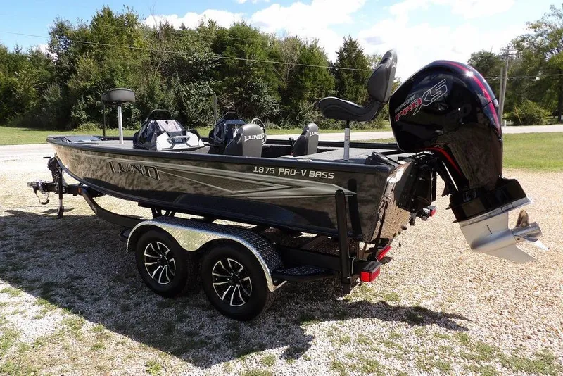 Slide: The Image of 2026 Lund 1875 Pro-V Bass XS boat on trailer, parked outdoors. - 6