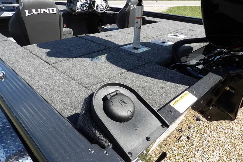 Slide: The Image of 2026 Lund 1875 Pro-V Bass XS boat interior with carpeted deck and seating. - 9