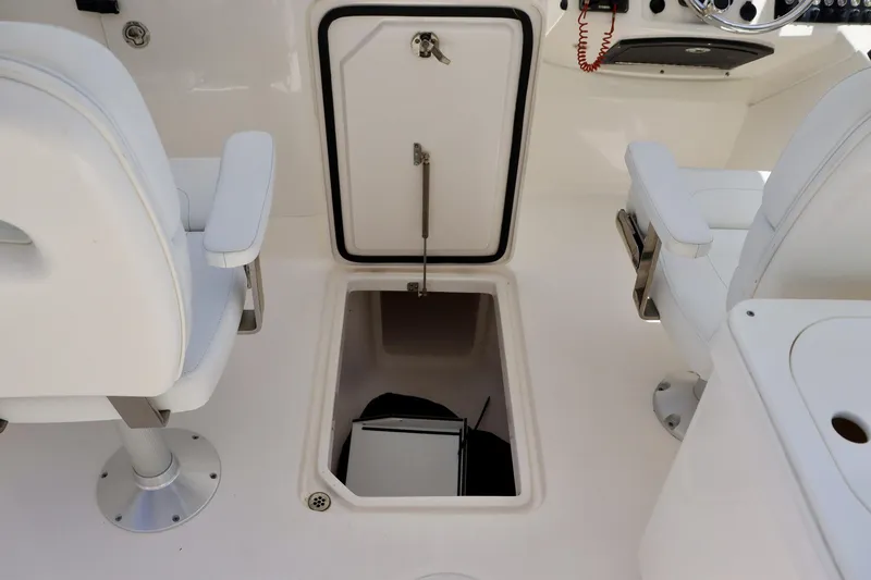 Slide: The Image of 2015 Everglades 245 CX boat interior with open storage compartment and white seating. - 13
