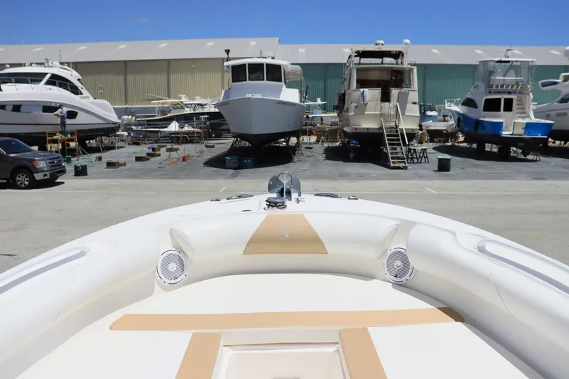 Slide: The Image of 2015 Everglades 245 CX boat in marina, surrounded by larger yachts and boats. - 15