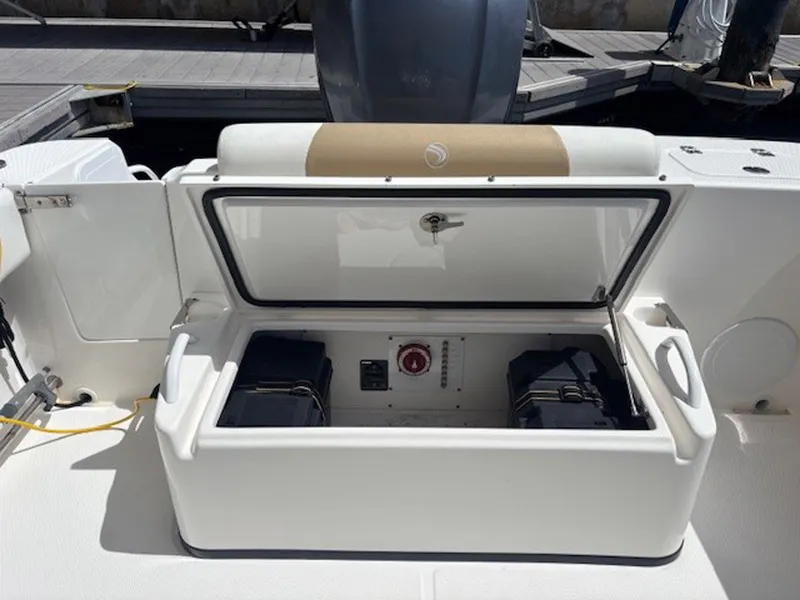 Slide: The Image of Open storage compartment on 2015 Everglades 245 CX boat, showing interior equipment and battery setup. - 17