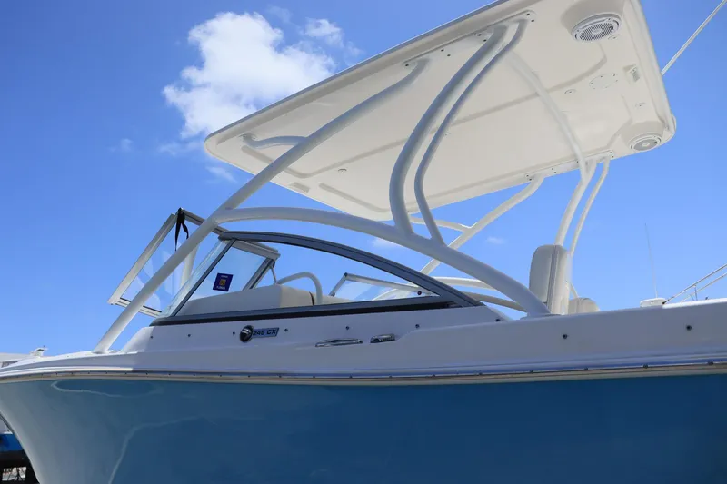 Slide: The Image of Everglades 245 CX 2015 boat with blue hull and white canopy under clear sky. - 5