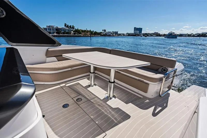 Slide: The Image of 2024 Azimut Verve 42 yacht deck with seating and table, overlooking serene waters. - 19