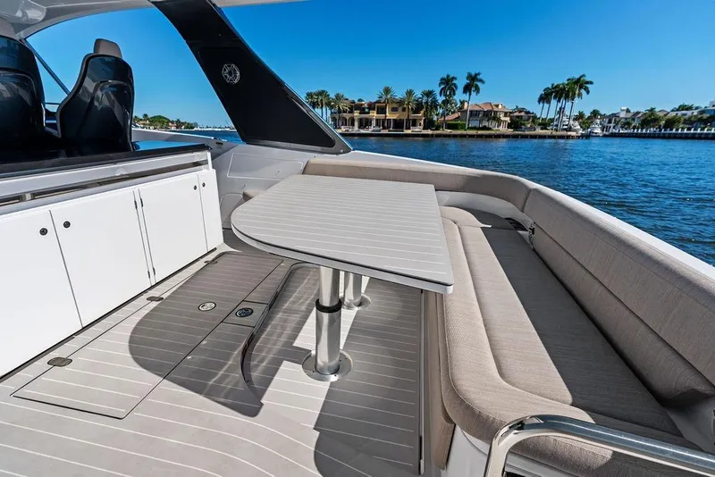 Slide: The Image of 2024 Azimut Verve 42 yacht interior with seating and table, overlooking waterfront homes. - 21