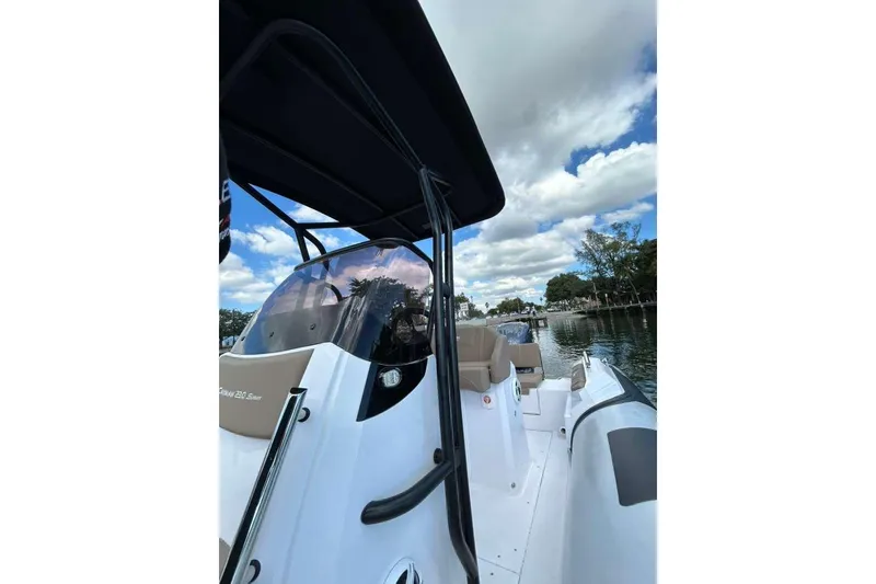Slide: The Image of 2026 Ranieri CAYMAN 23 Sport boat on a calm waterway under a partly cloudy sky. - 11